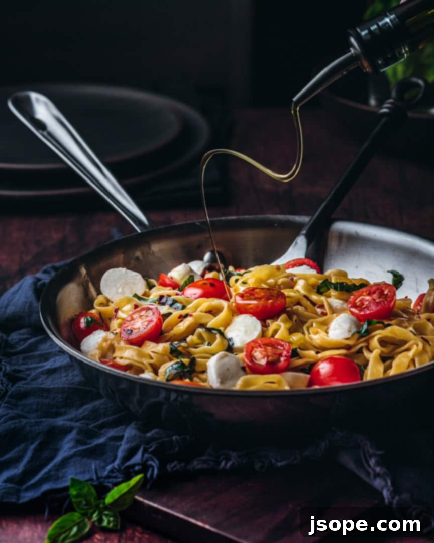 A generous drizzle of high-quality Extra Virgin Olive Oil over freshly prepared summer pasta with tomatoes and basil