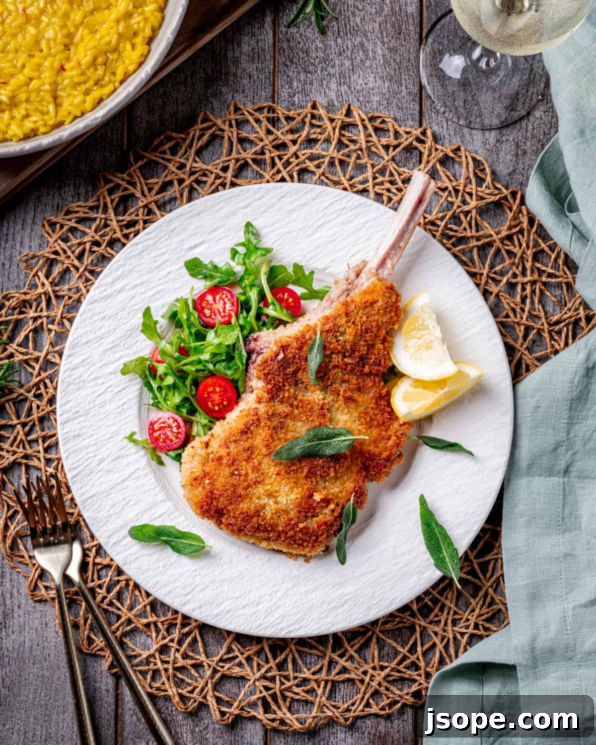 Close-up of a cooked Bone-In Veal Milanese chop with lemon and arugula salad