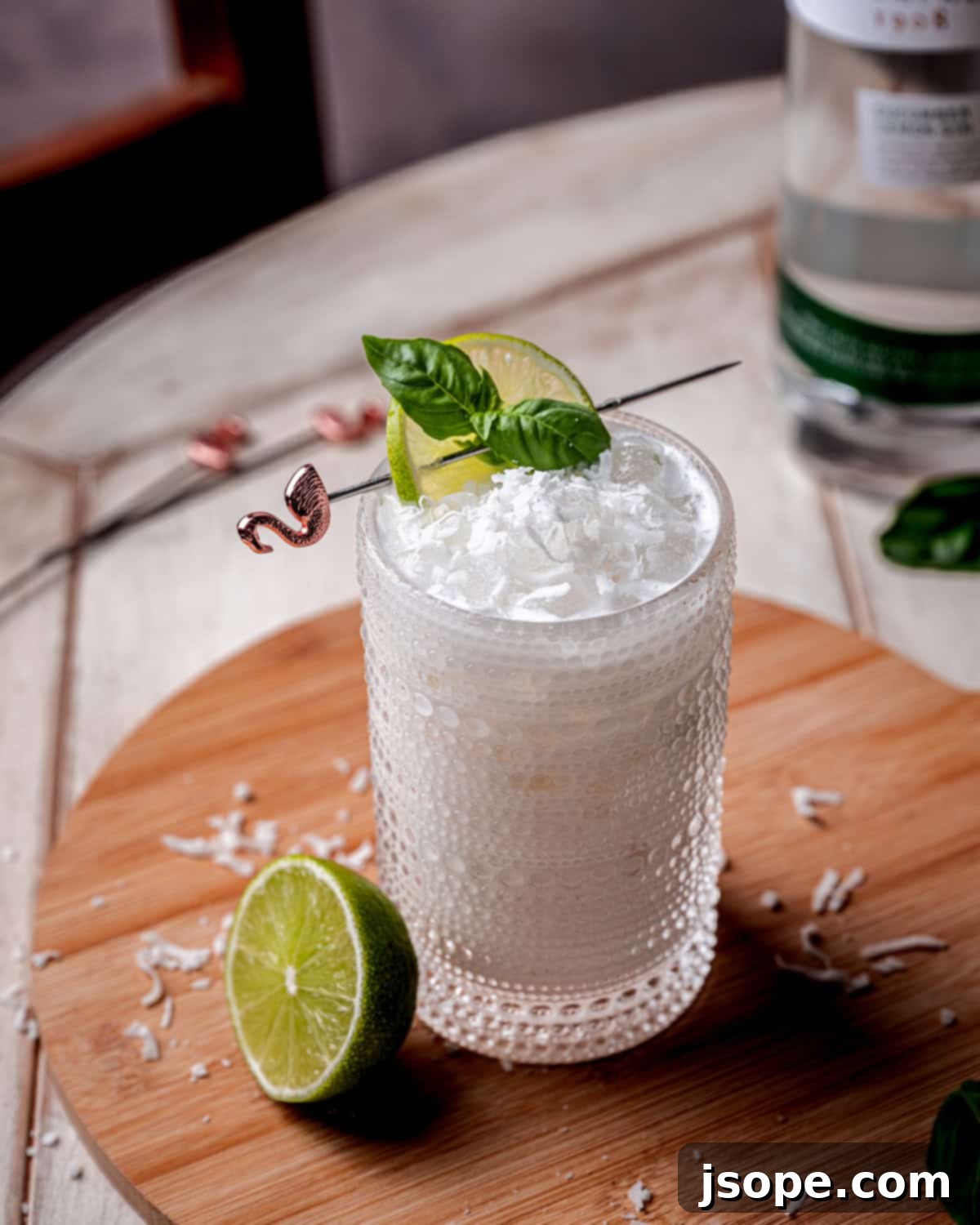 Close-up of Shimmy Shimmy Coconut Basil Lime Gin Cocktail with lime and basil garnish