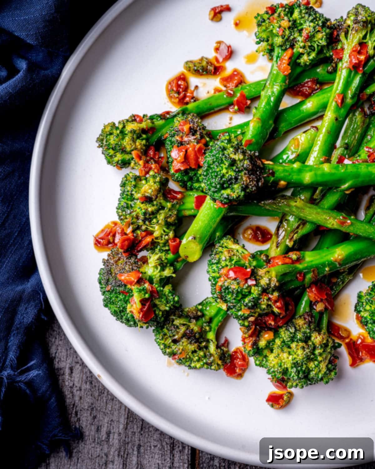 Fresh broccolini being sautéed in a large skillet with Calabrian chili paste and butter, creating a delicious char.