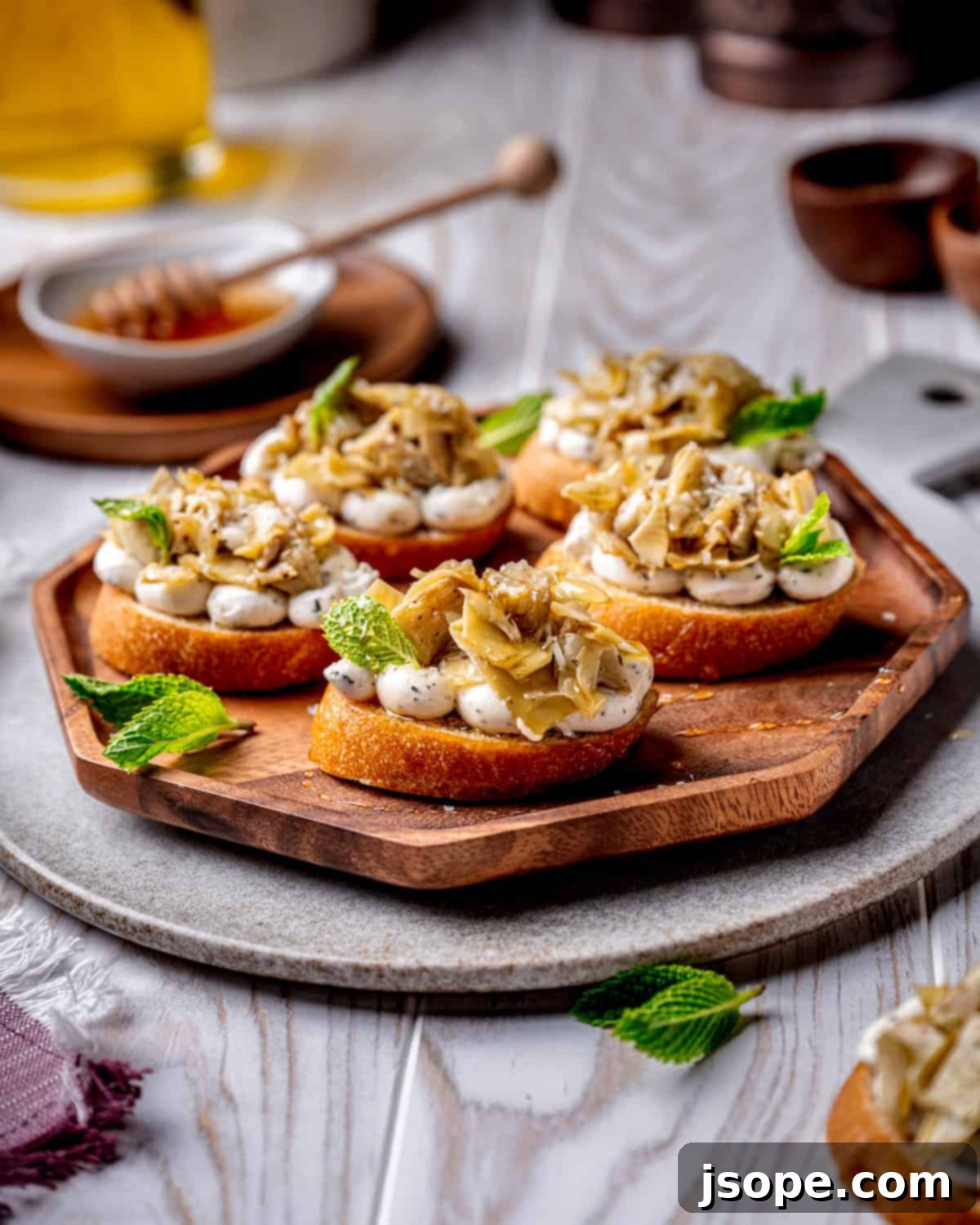 Close-up of Marinated Artichoke Hearts Crostini, showcasing the vibrant colors and appealing textures of this appetizer.