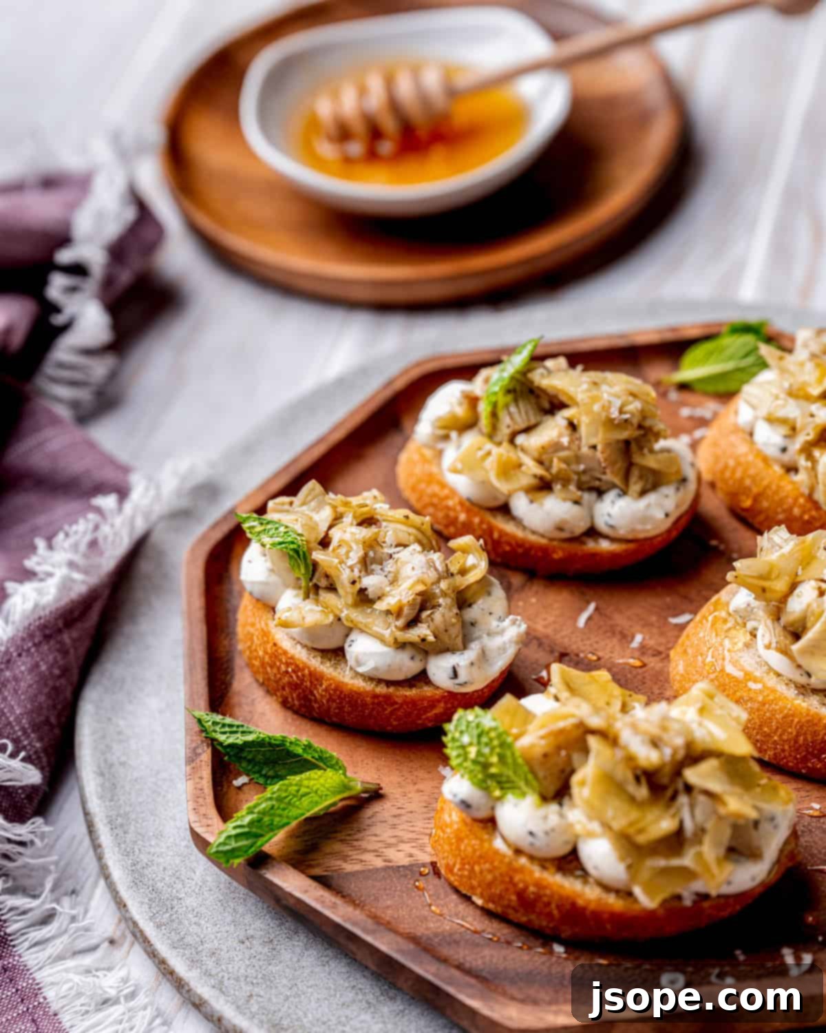 Marinated Artichoke Hearts Crostini in preparation, showing the artichokes being sautéed in a pan.