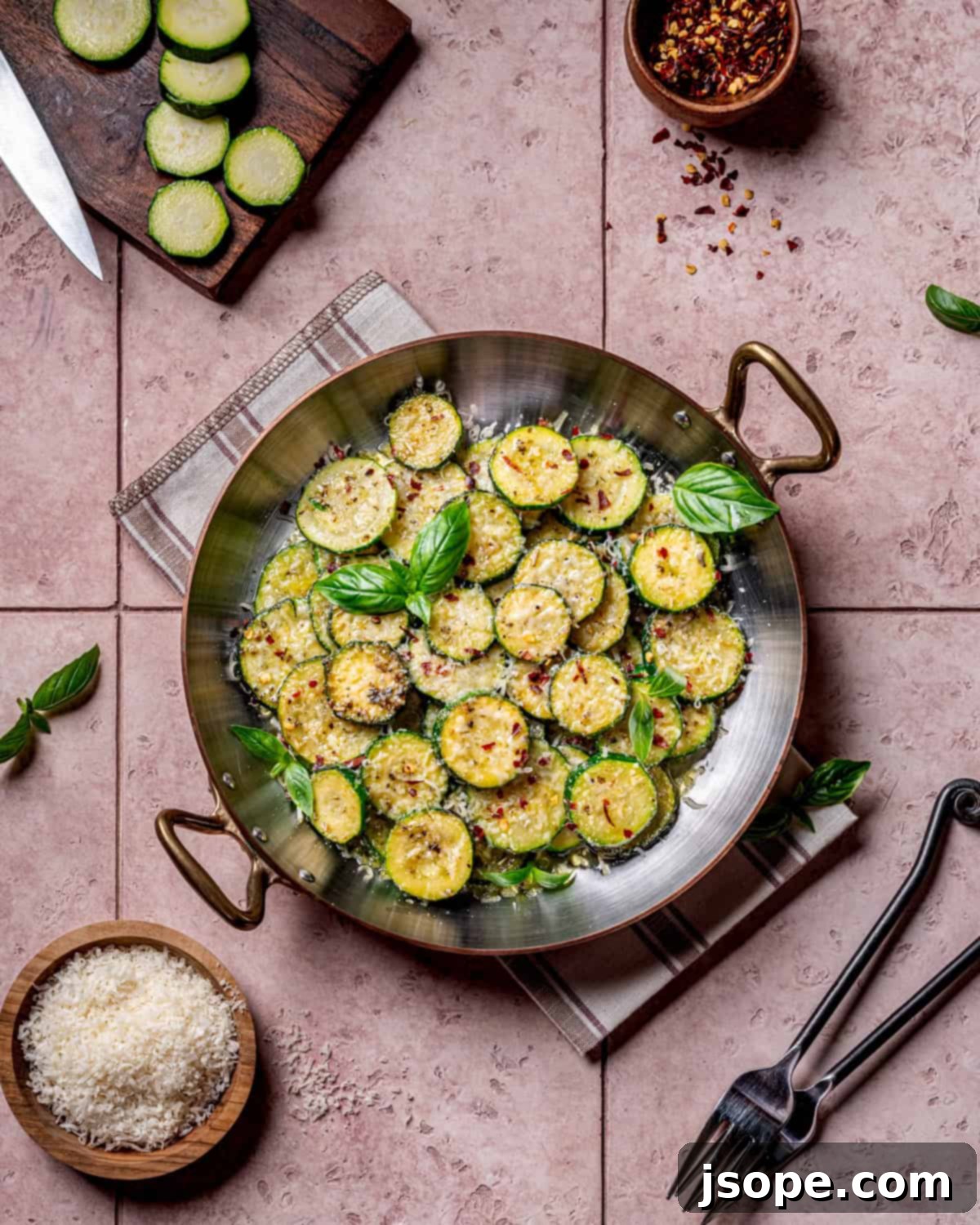 Italian Herb Sautéed Zucchini - side view on a plate with fresh basil
