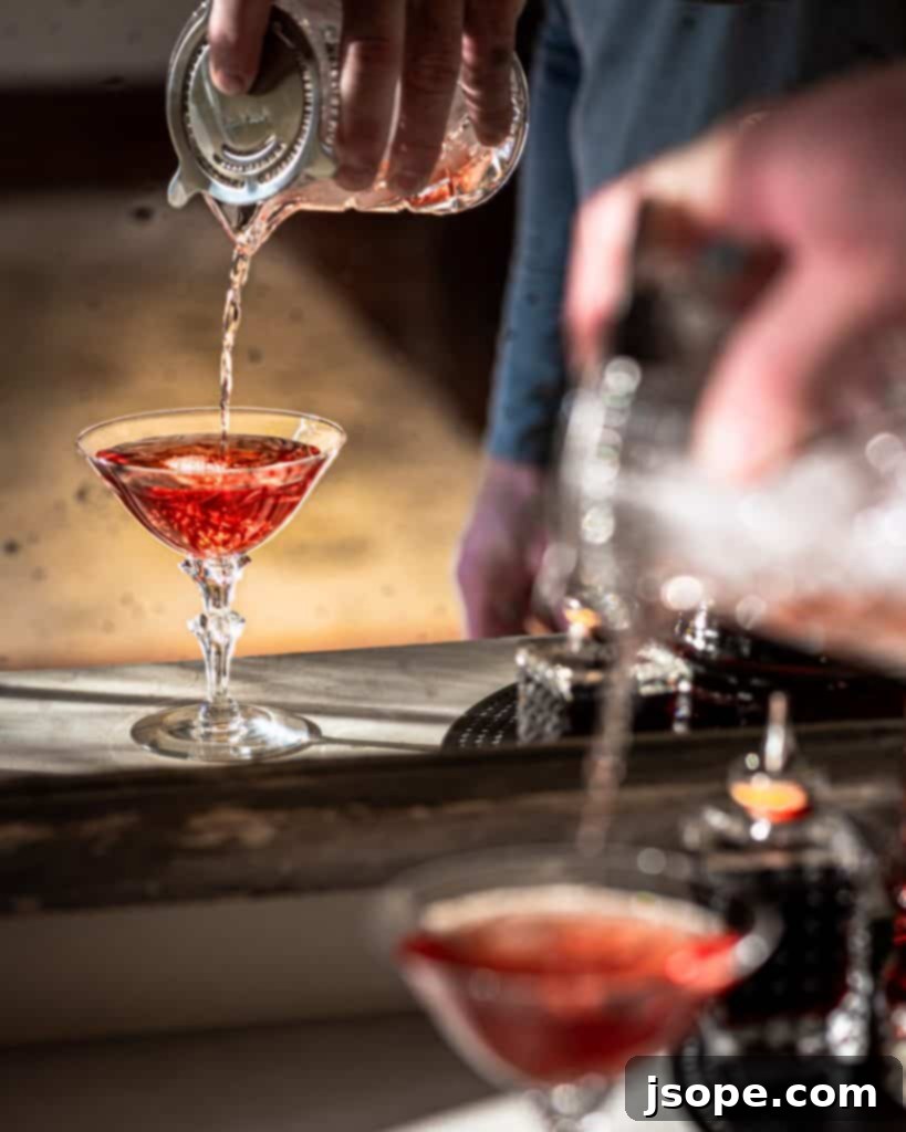 Close-up of a Southern Sunset Bourbon and Rye Whiskey Cocktail with an orange garnish and a hint of flame
