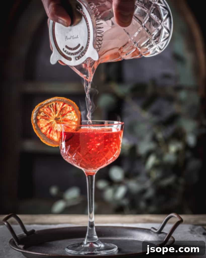 Southern Sunset cocktail being poured into a flaming Chartreuse-rinsed glass