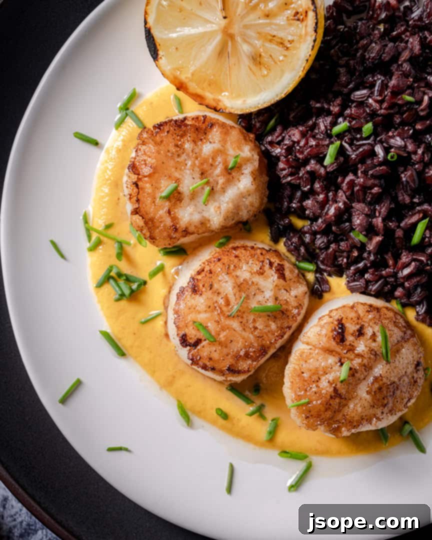 Perfectly Seared Scallops garnished with fresh herbs and served with Golden Romesco Sauce.