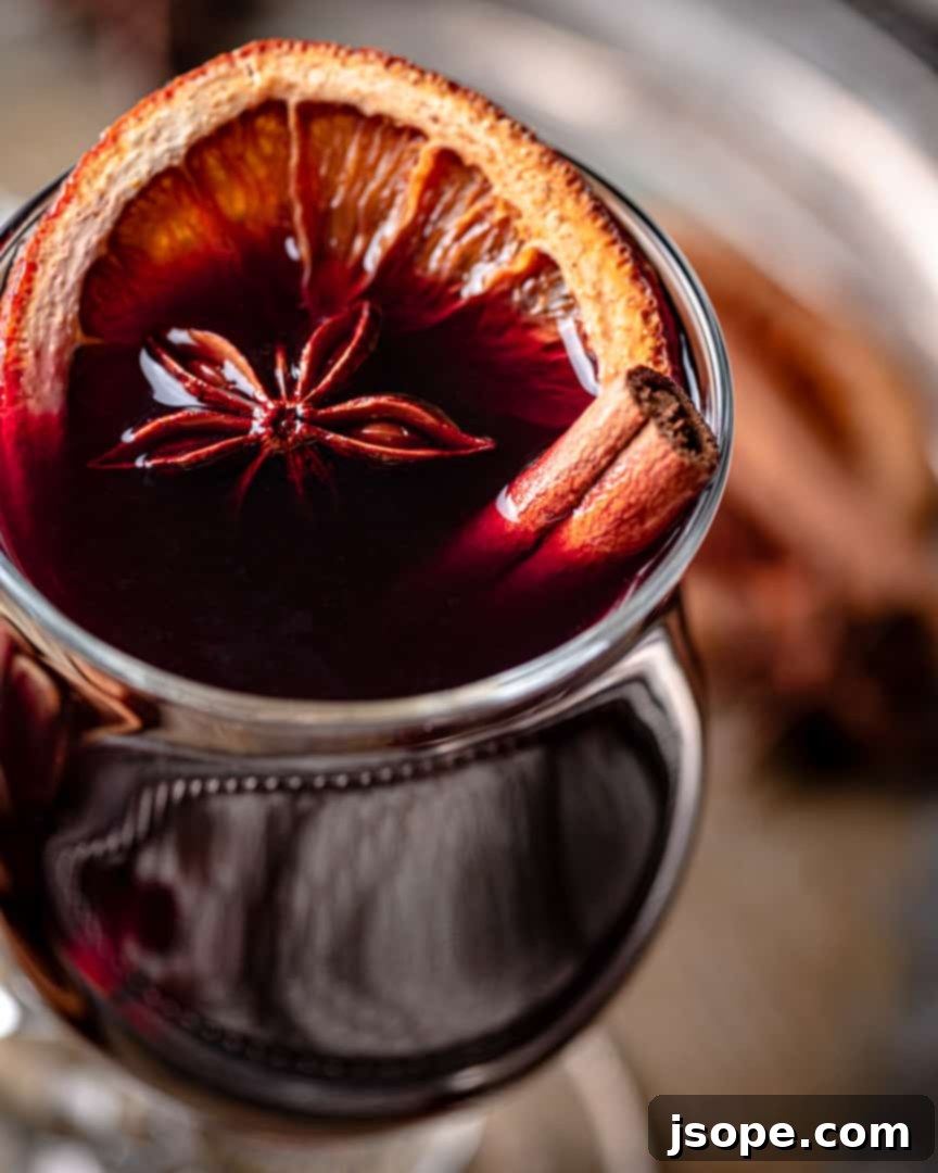 Ingredients for Mulled Wine with Amaretto and Brandy simmering gently in a saucepan.