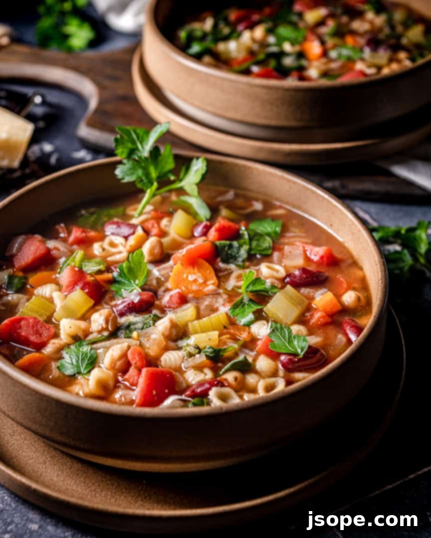 Close-up of a rustic wooden spoon scooping out a generous portion of Hearty Vegetable Pasta Soup, highlighting the vibrant vegetables, beans, and mini pasta shells.