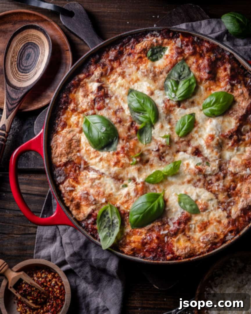Baked Rigatoni with Tomato Herb Meat Sauce, a hearty Italian pasta al forno dish with melted cheese and fresh herbs.