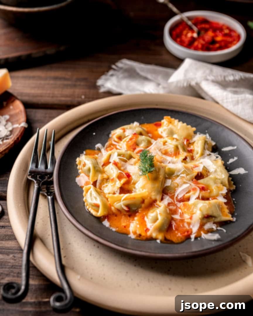 A plated dish of Fava Bean Agnolotti with Calabrian Chili Butter Sauce, garnished with fresh herbs and Parmesan.