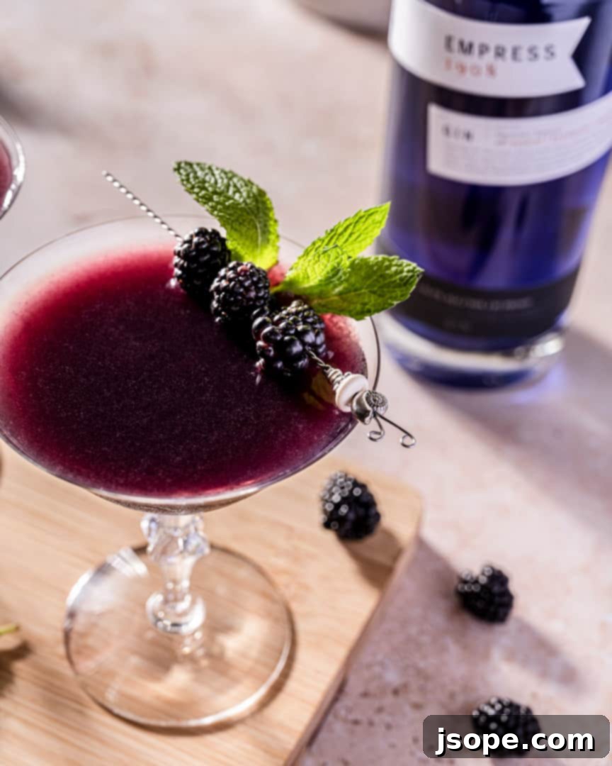 Blackberry Mint Gin Bliss 3 Close-up of Muddled Blackberry Mint Gin Cocktail in a glass with a mint sprig