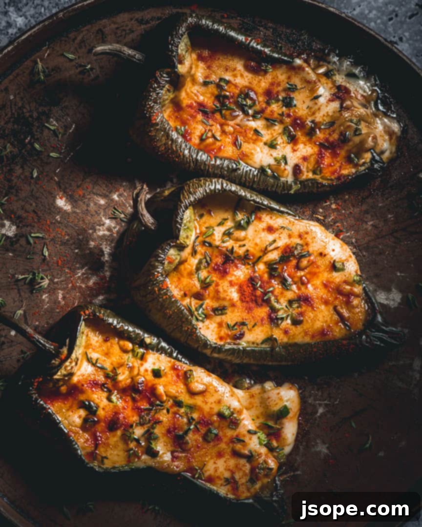 Close-up of baked Cheese Stuffed Poblano Peppers garnished with herbs