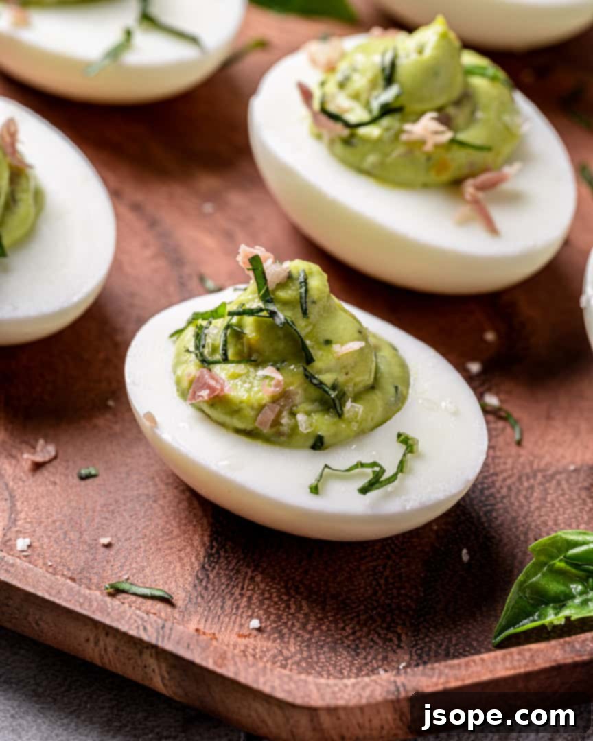 Close-up of a platter of Green Eggs and Ham Deviled Eggs garnished with fresh basil