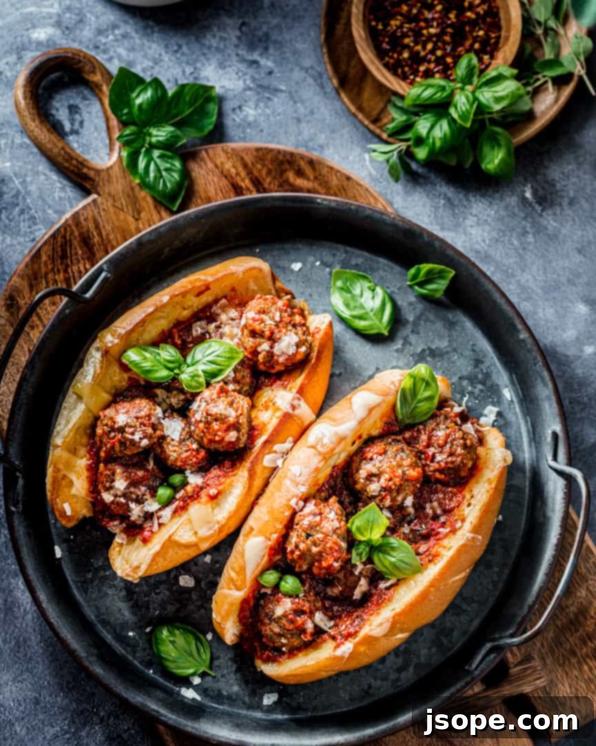 Italian Meatball Sub Sandwiches: Two hearty meatball sub sandwiches overflowing with meatballs and marinara sauce, topped with melted cheese.